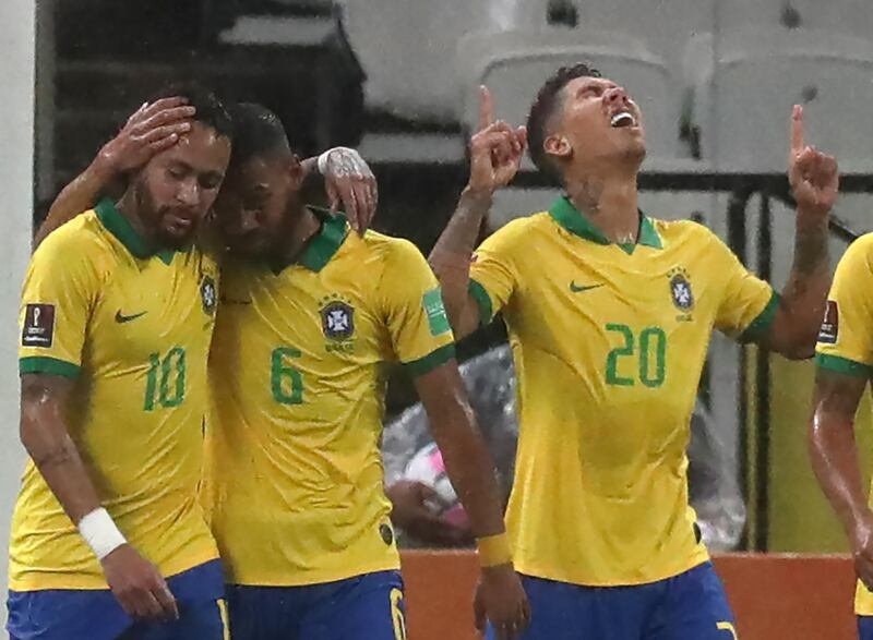 Roberto Firmino (R) celebrates next to teammates Neymar and Renan Lodi after scoring against Bolivia. AFP