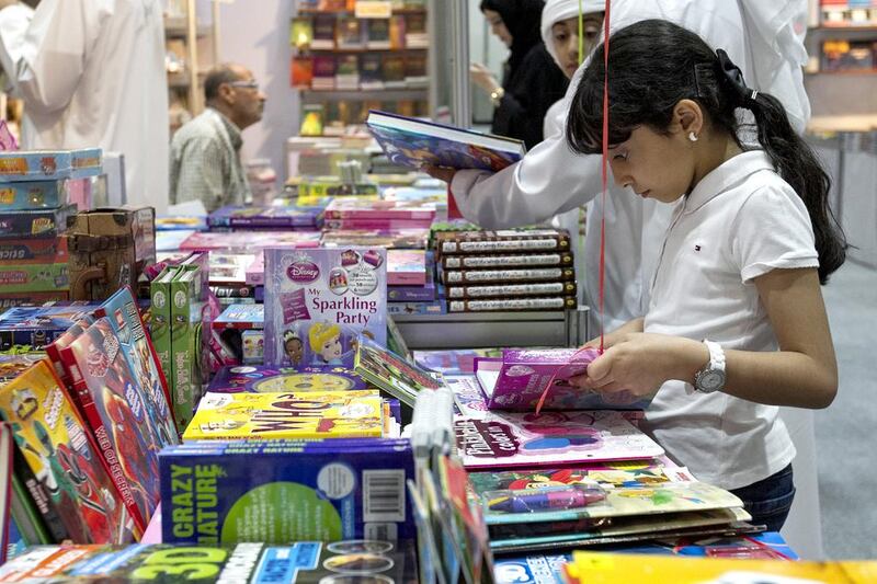 A young visitor checks out a book during the Abu Dhabi Book Fair. Mona Al-Marzooqi/ The National
