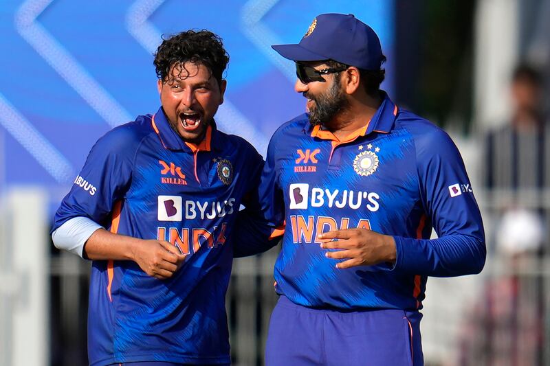 India's Kuldeep Yadav, left, celebrates with captain Rohit Sharma the dismissal of Australia batter Alex Carey for 38. AP