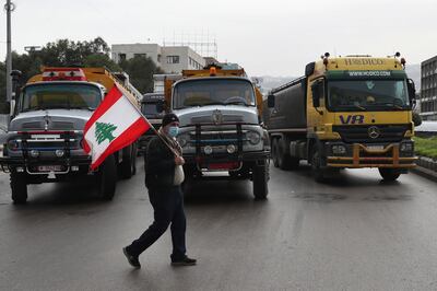 Lorry drivers block a main road during a general strike in Lebanon in January last year. AP 