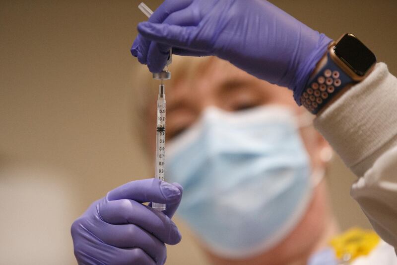 Tami Jeffries, R.N., prepares the first locally-available dose of the Pfizer-BioNTech COVID-19 vaccine at Mary Washington Hospital in Fredericksburg, Va. on Tuesday, Dec. 15, 2020. (Mike Morones/The Free Lance-Star via AP)