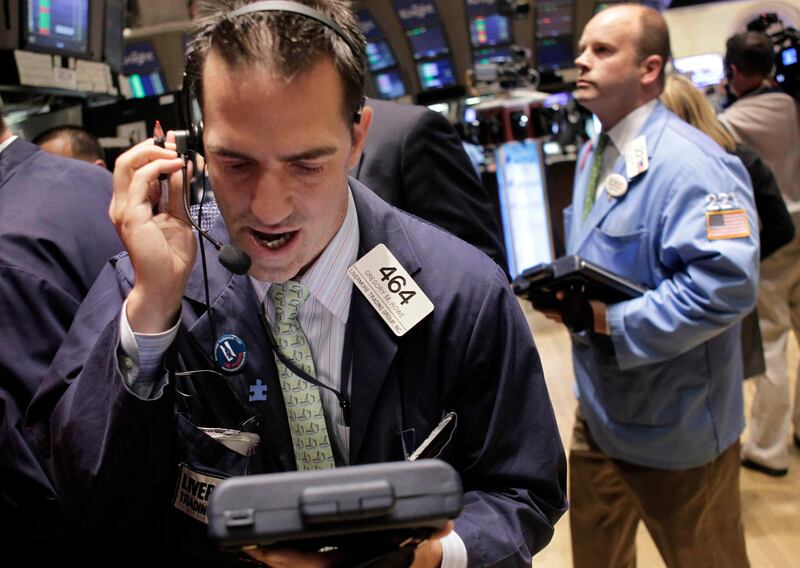 In this July 25, 2011 photo,trader Gregory M. Rowe (left) works on the floor at the New York Stock Exchange in New York.  The deadlock over raising the U.S. debt ceiling continued to weigh on stocks and the dollar Tuesday, July 26, after President Barack Obama warned that his country was dangerously close to a default.  (AP Photo/Seth Wenig) )