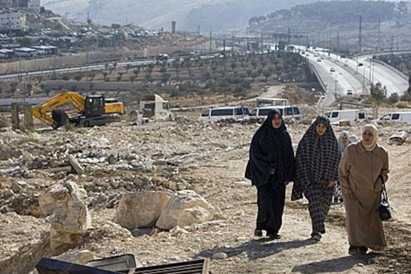 Members of Palestinian family walk near the rubble of their house in November 2010, which was demolished by Jerusalem municipality workers because it was illegally built in occupied east Jerusalem.