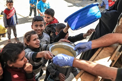 Volunteers of World Central Kitchen hand out food to Palestinian children in Gaza. Getty