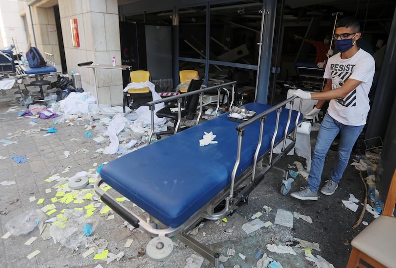 A man wearing a face mask moves a gurney at a damaged hospital following Tuesday's blast in Beirut. Reuters