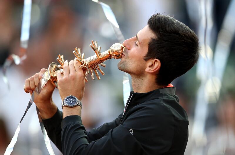 MADRID, SPAIN - MAY 12: Novak Djokovic of Serbia celebrates victory as he kisses the winners trophy following the men's singles final against Stefano Tsitsipas of Greece during day nine of the Mutua Madrid Open at La Caja Magica on May 12, 2019 in Madrid, Spain. (Photo by Alex Pantling/Getty Images)