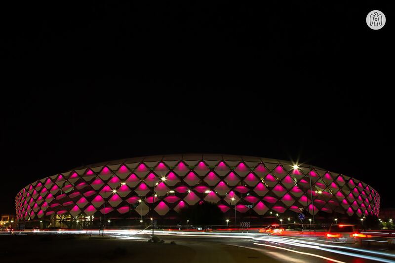 The Hazza bin Zayed Stadium in Al Ain is lit up in the maroon of Qatar's flag