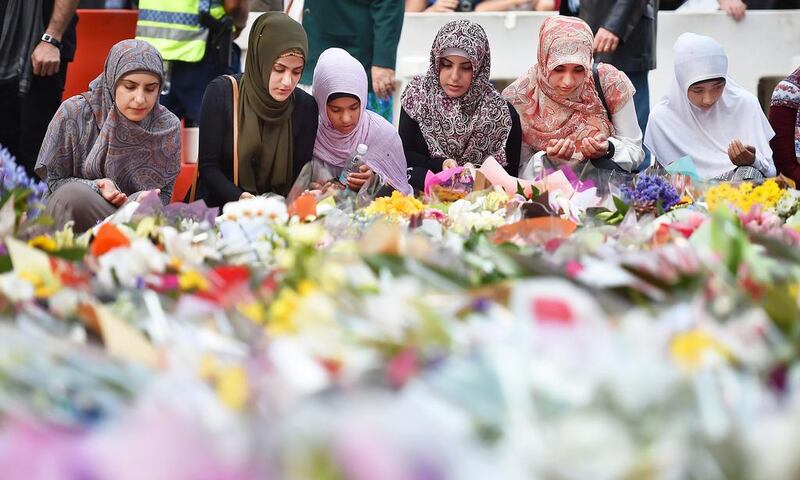 Young Muslim women lay flowers at a makeshift memorial near the scene of a fatal siege in the heart of Sydney's financial district on December 16, 2014. Peter Parks/AFP PHOTO

