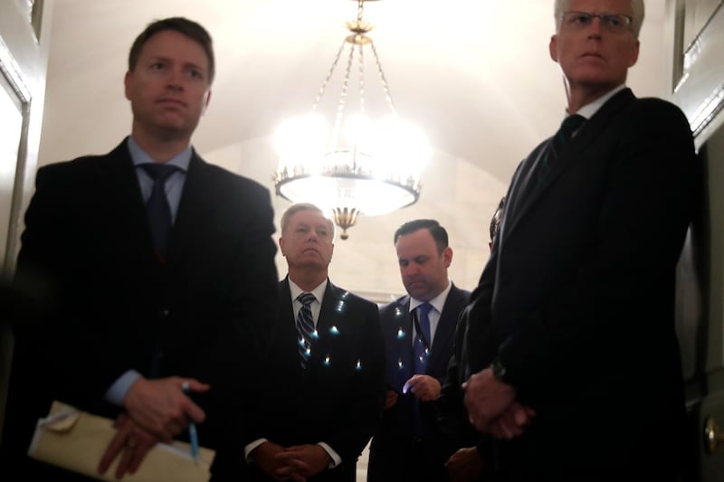 US senator Lindsey Graham, second from left, listens as President Donald Trump speaks in the Diplomatic Room of the White House in Washington, on Sunday, October 27, 2019. AP Photo