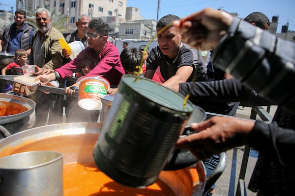Palestinians gather to receive food cooked by a charity kitchen in Rafah. Reuters