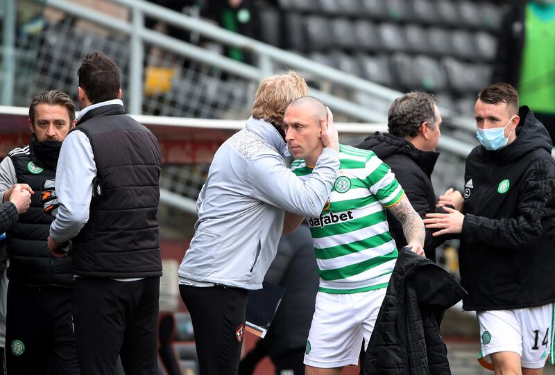 Scott Brown of Celtic is embraced by members of staff following the draw against Dundee United.