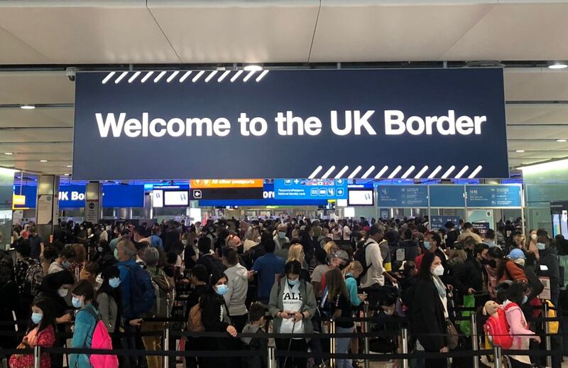 People wait in line at the arrivals desk at Heathrow Airport, as Covid rules cause long delays for travellers. Reuters