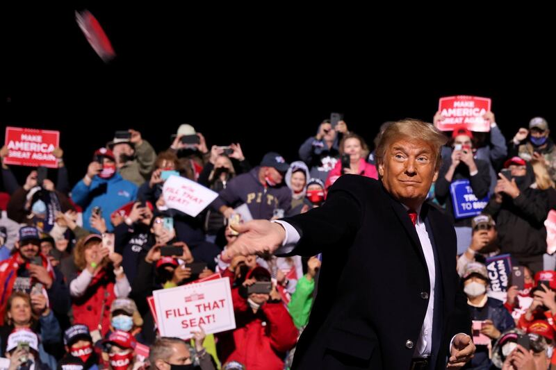 U.S. President Donald Trump throws face masks to the crowd as he arrives to hold a campaign rally at John Murtha Johnstown-Cambria County Airport in Johnstown, Pennsylvania, U.S. REUTERS