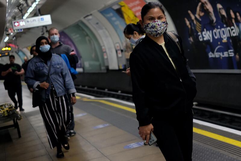 (FILES) In this file photo taken on May 13, 2020, commuters wearing PPE (personal protective equipment), including a face mask as a precautionary measure against COVID-19, travel in the morning rush hour on TfL (Transport for London) London underground Victoria Line trains from Finsbury park towards central London. Ethnic minorities in Britain are paying with their lives after years of government neglect has left them uniquely vulnerable to the coronavirus pandemic, according to research published Tuesday, October 27. / AFP / Isabel INFANTES
