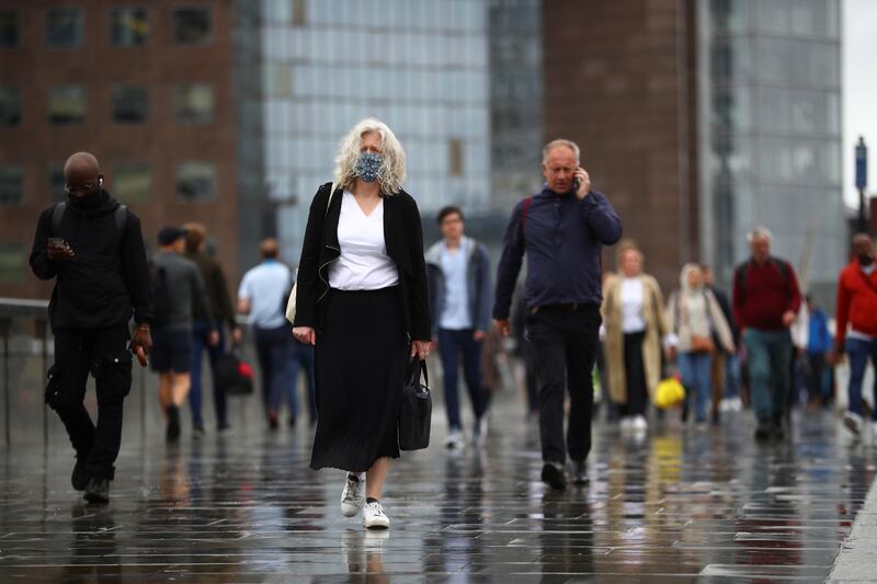 A commuter wearing a mask crosses London Bridge. UK Prime Minister Boris Johnson said on Monday that it was time to end most Covid-19 restrictions and for the country to 'learn to live with coronavirus'.