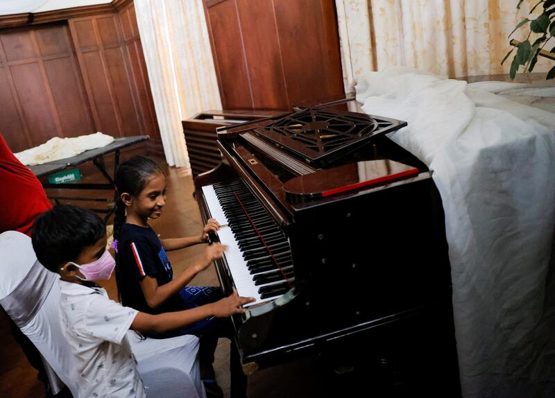 Children play the piano inside the president's house in Colombo. Reuters