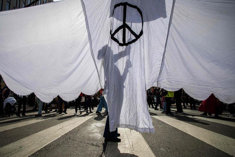 A woman holds a white peace flag sign as people march in Los Angeles.  AFP