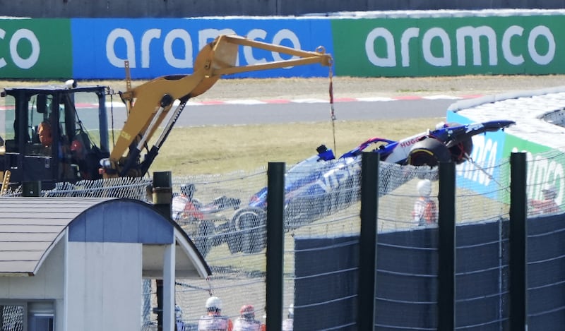 Officials remove the car of RB driver Daniel Ricciardo at Suzuka. EPA