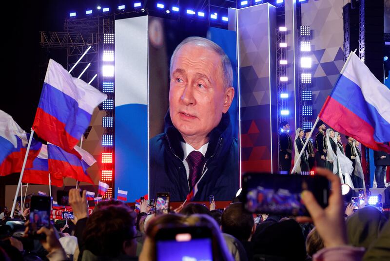 Mr Putin is seen on a big screen at the concert, which took place on Red Square in Moscow on Monday. Reuters