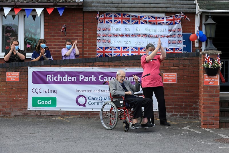 98-year-old care home resident Albert Rose carers and staff applaud him, outside Richden Park care home in Scunthorpe, northern England on May 4, 2020, following an appeal for people to come forward and help the resident celebrate his birthday, after his only surviving relative was not able to visit due to the COVID-19 pandemic. - Following a social media appeal, members of the public gathered at a safe distance to help 98-year-old care home resident Albert Rose celebrate his 98th Birthday, after his only surviving family member, his grandson, could not be with him due the COVID-19 pandemic. (Photo by Lindsey Parnaby / AFP)