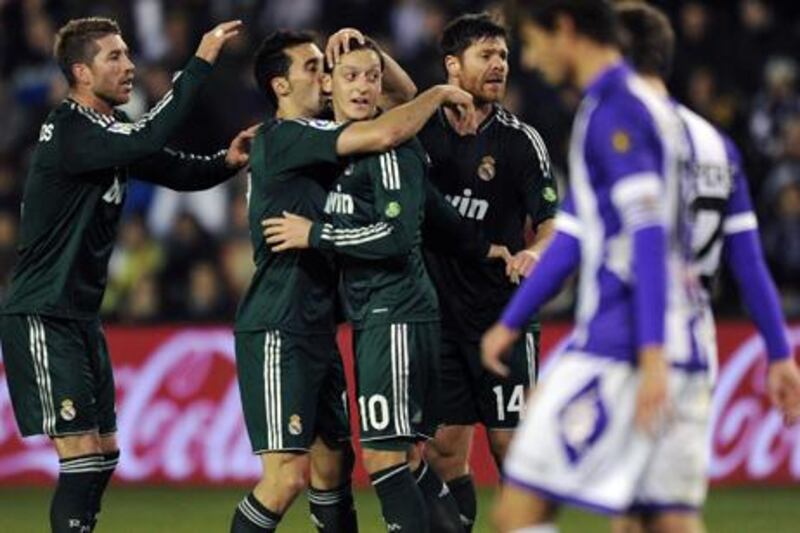 Real Madrid's Mesut Ozil (centre) celebrates with teammates after scoring against Real Valladolid.