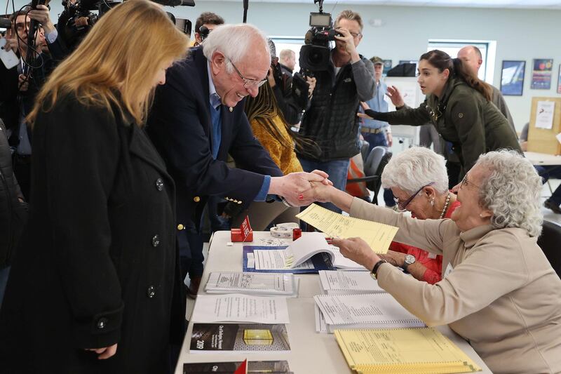 Democratic presidential candidate Senator Bernie Sanders and his wife Jane O'Meara Sanders greet poll workers before voting in their state's primary election at the Robert Miller Community Center in Burlington, Vermont. AFP