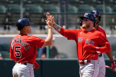 Boston Red Sox' Alex Verdugo celebrates with Enrique Hernandez (5) after scoring on a two-run double by J.D. Martinez in the fifth inning of a spring training baseball game against the Atlanta Braves on Tuesday, March 23, 2021, in North Port, Fla. (AP Photo/John Bazemore)