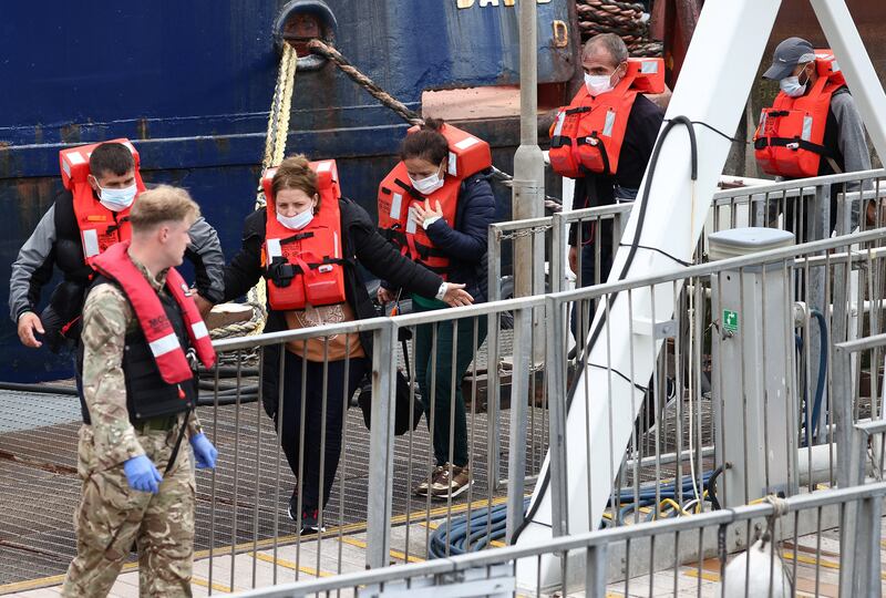 Migrants are escorted into Dover by a member of the UK military after being rescued while attempting to cross the English Channel. Reuters