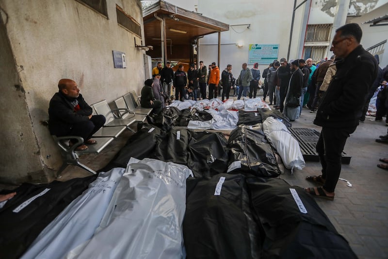 People mourn by the bodies of victims of an Israeli strike in Rafah. Getty Images