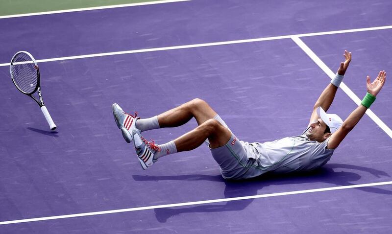 Novak Djokovic falls to the court as he celebrates defeating Rafael Nadal in Miami on Sunday. Rhona Wise / EPA

