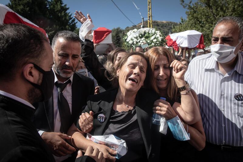 BEIRUT, LEBANON - AUGUST 17: Family members mourn as the coffins of firefighters Charbel Hetti, Najeeb Hetti and Charbel Karem who were killed in the August 4th, Beirut port explosion are carried to the church during their funeral service in their hometown of Qartaba on August 17, 2020 in Beirut, Lebanon. Najeeb Hetti, 27  his cousin Charbel Hetti, 22 and his sisters husband Charbel Karam, 37 were killed during the Beirut port explosion along with 7 other firefighters from the Karatina fire department, who were the first responders to the blaze. The remains of Najeeb and Charbel were found on August 13th,  however the family refused to bury them until the body of Charbel Karam was found, his remains were recovered on August 15th.  There has been little visible support from government agencies to help residents clear debris and help the displaced, although scores of volunteers from around Lebanon have descended on the city to help clean. (Photo by Chris McGrath/Getty Images)