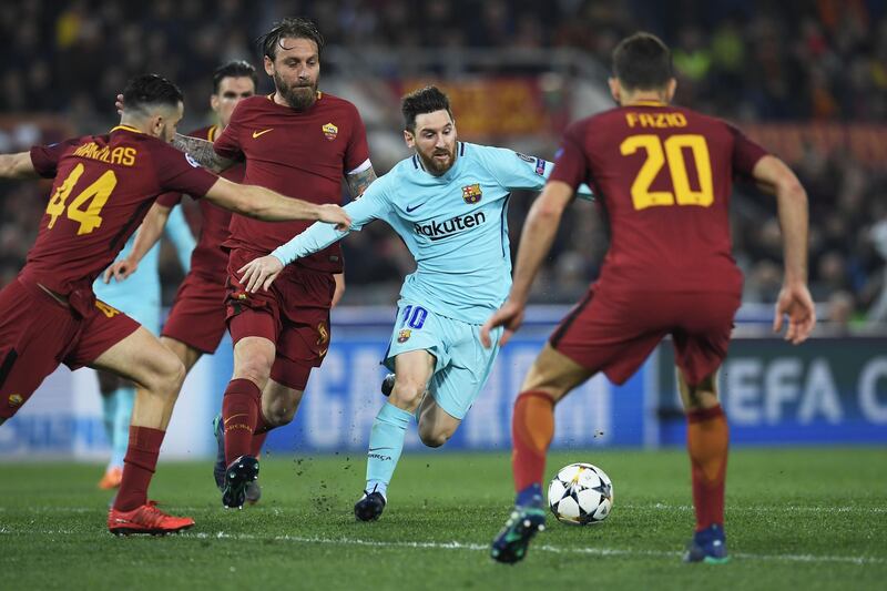 Barcelona forward Lionel Messi, centre, vies for the ball with Roma midfielder Daniele de Rossi, second from right, during their Uefa Champions League quarter-final second-leg match in Rome. Lluis Gene / AFP