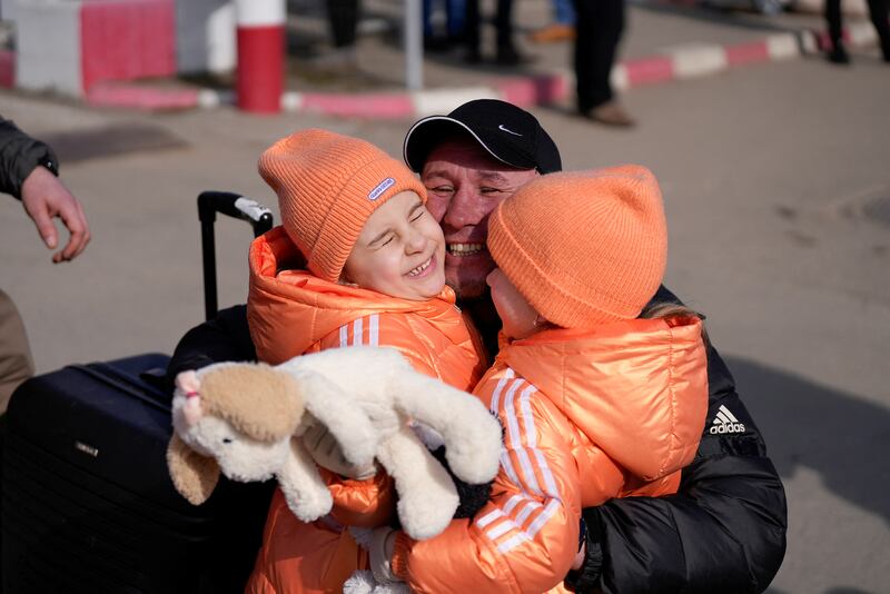 Children reunite with their father at the border crossing in Sighetu Marmatiei, Romania. Reuters