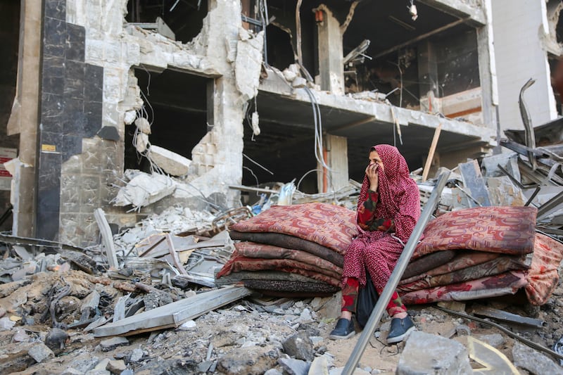 A Palestinian woman reacts as she sits amidst the rubble of the hospital. AFP
