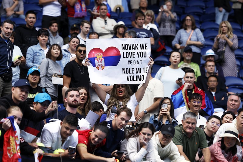 A spectator holds a placard during the match between Novak Djokovic and Adrian Mannarino. EPA