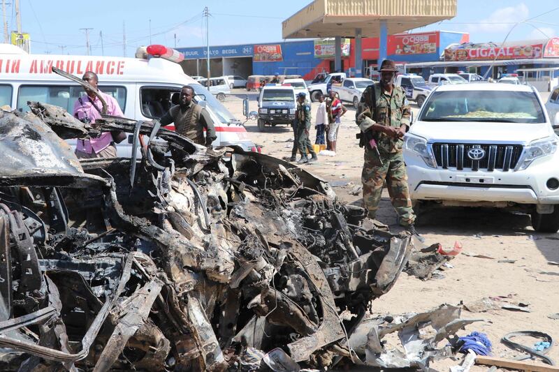 A soldier is seen next to the wreckage of car that was damaged during the car bomb that exploded in Mogadishu. AFP
