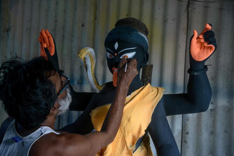 An artist works on the face of a semi-finished clay idol of the Hindu goddess Kali in Siliguri on October 18, 2019. The worship of Hindu deity Kali takes place on October 27 in the eastern Indian states along with 'Diwali', the Festival of Lights, marking the victory of good over evil and commemorating the time when the Hindu god Lord Rama achieved victory over Ravana. AFP