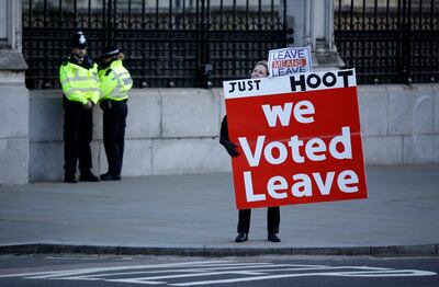 A pro-Brexit demonstrator holds a banner outside the Houses of Parliament in London, Tuesday Jan. 8, 2019. The British government on Tuesday ruled out seeking an extension to the two-year period taking the country out of the European Union ahead of a crucial parliamentary vote next week on Prime Minister Theresa May's Brexit deal. (AP Photo/Matt Dunham)
