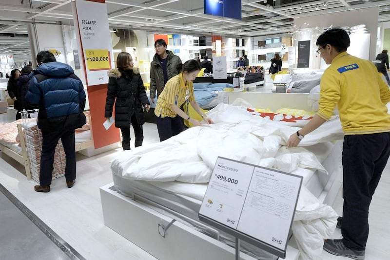 Employees work on a display as visitors browse through products at the Ikea store in Gwangmyeong. Ahn Eun-na / News1 / Reuters