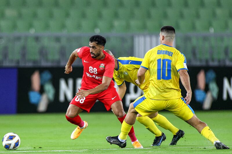 Shabab Al Ahli midfielder Majed Hassan breaks clear of Al Gharafa players. AFP