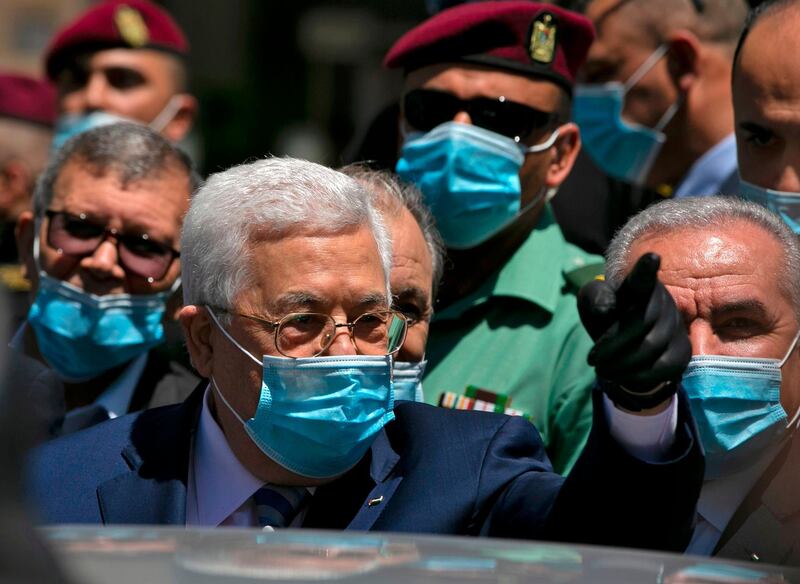 Palestinian President Mahmoud Abbas calls on people to wear protective masks as he walks in a street in the West Bank city of Ramallah.  AFP
