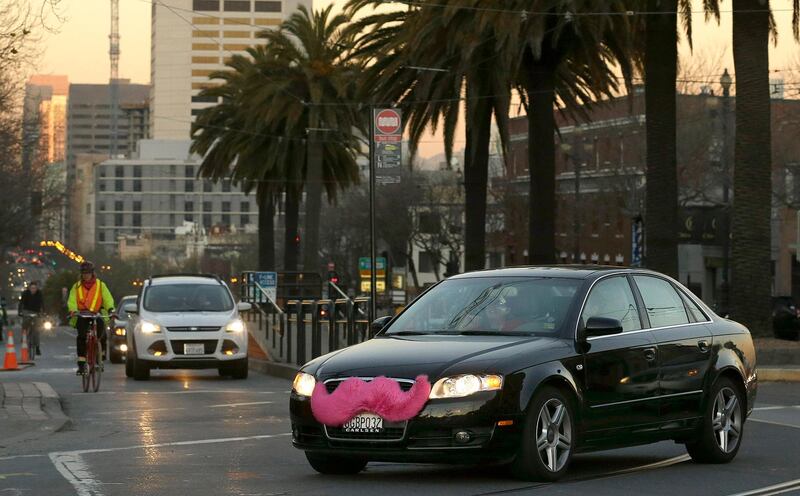 FILE - In this Jan. 17, 2013, file photo, a Lyft car crosses Market Street in San Francisco. A California law that allows Uber and Lyft drivers to have a single business license to drive anywhere in the state is depriving San Francisco of fees that could offset maintenance and traffic costs created by ride-hailing services, San Francisco officials said in a lawsuit filed on Thursday, Feb. 8, 2018, against the state. (AP Photo/Jeff Chiu, File)
