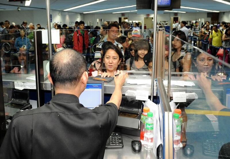 Filipinos at Manila airport, where millions of them face scrutiny by emigration officials before being allowed to travel abroad to work.  Jay Directo / AFP