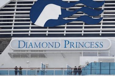 Masked passengers look on from on board the coronavirus-hit Diamond Princess cruise ship docked at Yokohama Port, south of Tokyo, Japan, February 20, 2020. REUTERS/Kim Kyung-Hoon