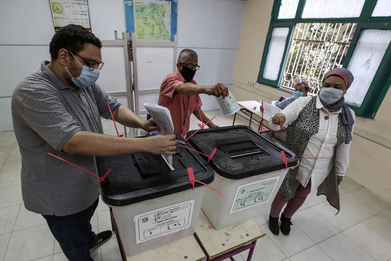 Egyptians, mask-clad due to the COVID-19 coronavirus pandemic, cast their ballots at a polling station. AFP