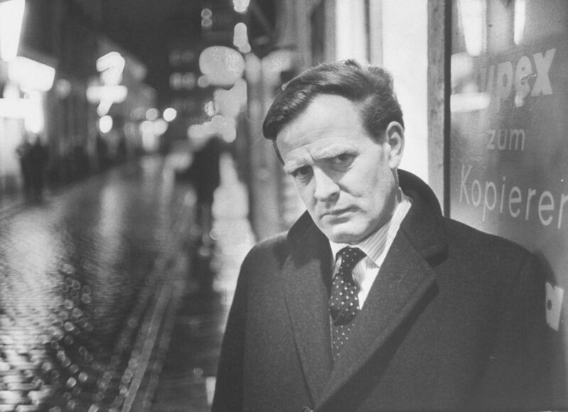 As photographic setting for picture story of British spy-thriller writer David Cornwell, shown on dark rainy street in Hamburg, looking suitably furtive in spy manner, 1964.  (Photo by Ralph Crane/The LIFE Picture Collection via Getty Images)