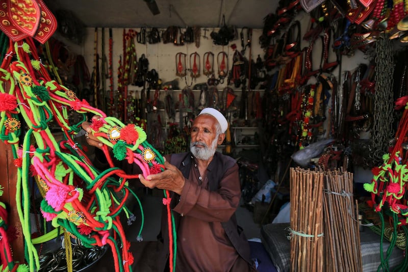 epa08562320 Ornaments for sacrificial animals are on sale, on a road side ahead of the Muslim festival of Eid al-Adha in Peshawar, Pakistan, 23 July 2020. Eid al-Adha is the holiest of the two Muslims holidays celebrated each year, it marks the yearly Muslim pilgrimage (Hajj) to visit Mecca, the holiest place in Islam. Muslims slaughter a sacrificial animal and split the meat into three parts, one for the family, one for friends and relatives, and one for the poor and needy.  EPA/BILAWAL ARBAB