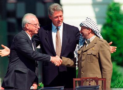 Israeli prime minister Yitzhak Rabin, left, and Palestinian leader Yasser Arafat shake hands marking the signing of the peace accord between Israel and the Palestinians, in Washington, on September 13, 1993. AP