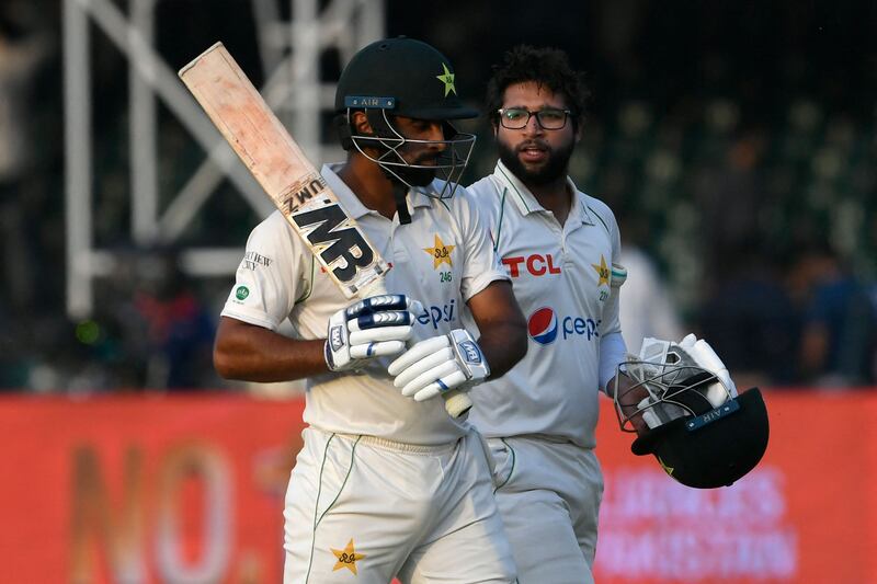 Pakistan's Abdullah Shafique, left, and Imam-ul-at the end of the fourth day's play at the Gaddafi Cricket Stadium in Lahore. AFP