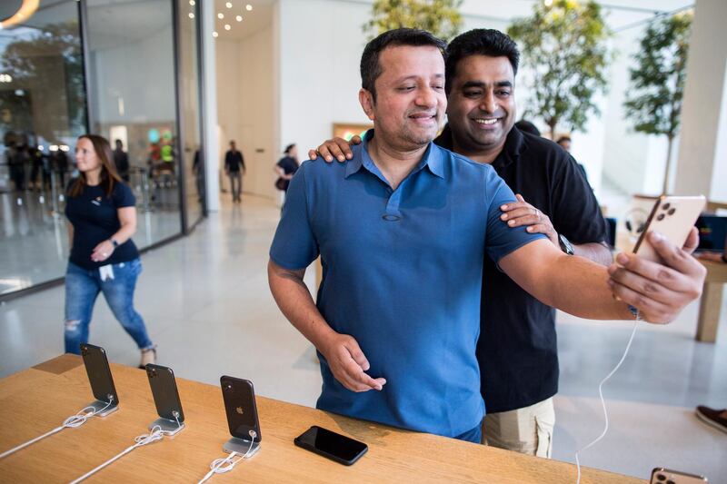 Customers look at the new iPhone 11 Pro in Dubai. EPA